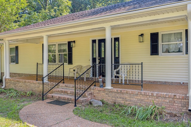 property entrance featuring a porch and a shingled roof