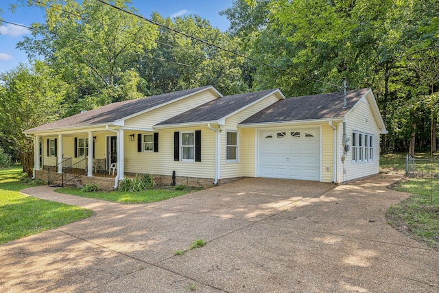 ranch-style home with covered porch, a garage, and driveway