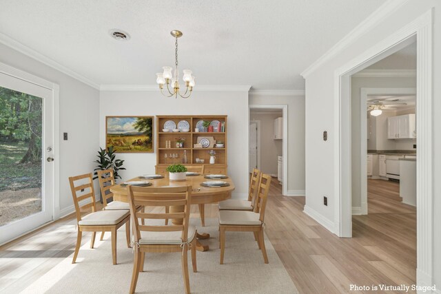 dining space with crown molding, ceiling fan with notable chandelier, and light hardwood / wood-style floors