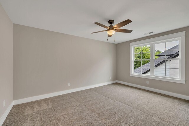 unfurnished room with ceiling fan and carpet