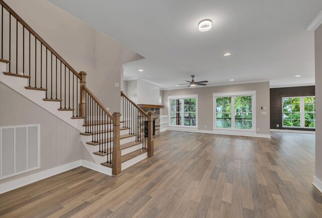 interior space featuring ceiling fan, ornamental molding, wood-type flooring, and a healthy amount of sunlight