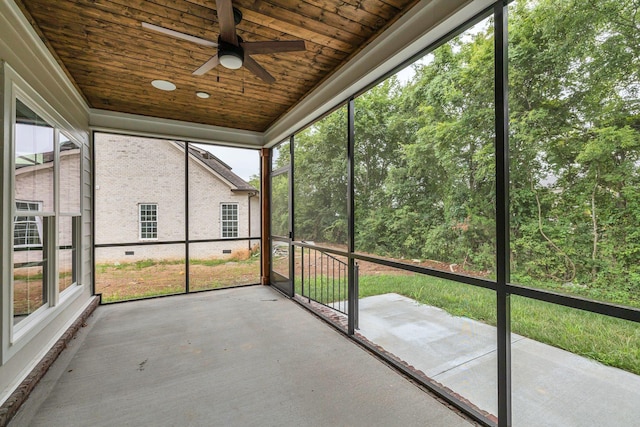 unfurnished sunroom with a ceiling fan and wood ceiling