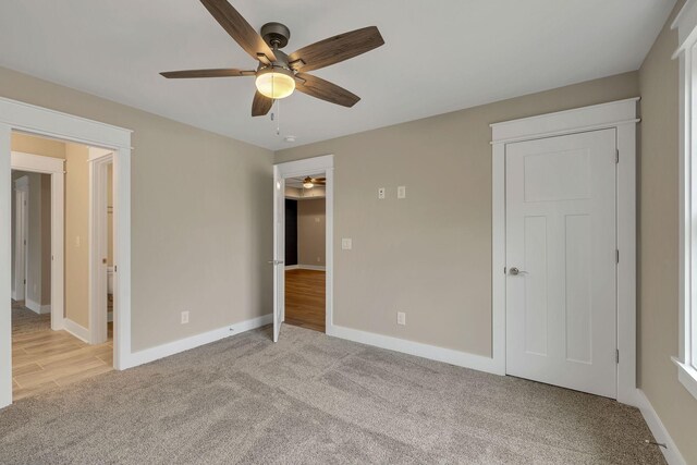 unfurnished bedroom with ceiling fan and light colored carpet