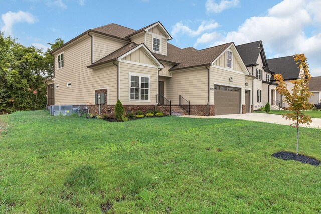 craftsman-style house featuring a garage, central AC, and a front yard