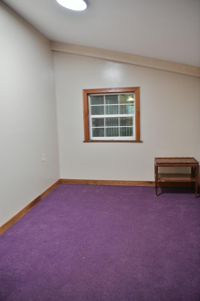 empty room featuring carpet and baseboards