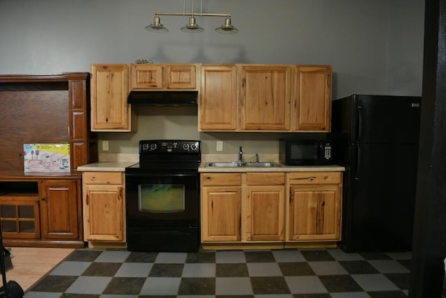 kitchen with dark tile patterned flooring, black appliances, sink, and pendant lighting