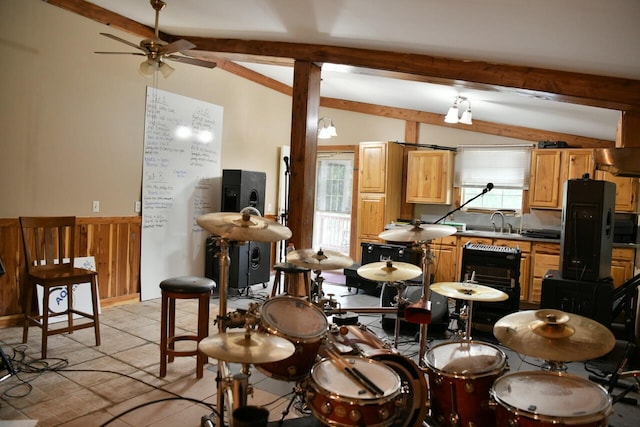 interior space featuring lofted ceiling with beams, ceiling fan, black refrigerator, light tile patterned floors, and sink