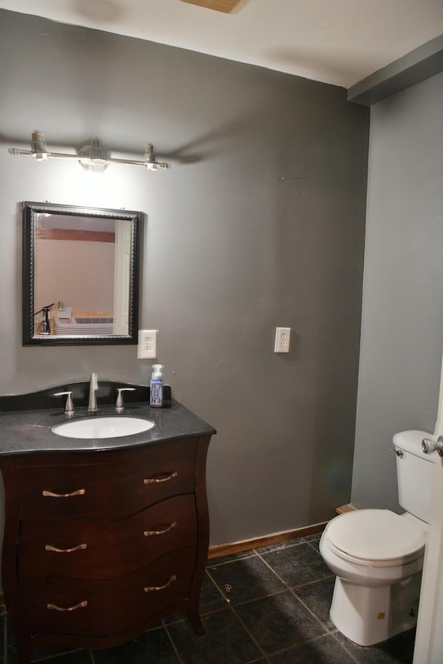 bathroom featuring toilet, tile patterned floors, vanity, and baseboards