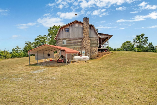 rear view of house featuring a yard and a carport