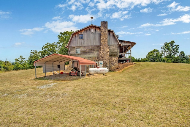 rear view of house featuring driveway, a barn, a gambrel roof, a yard, and a carport