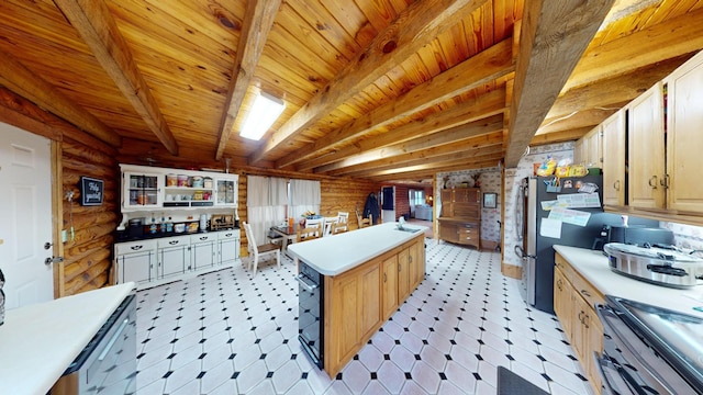 kitchen with appliances with stainless steel finishes, beam ceiling, light countertops, and rustic walls