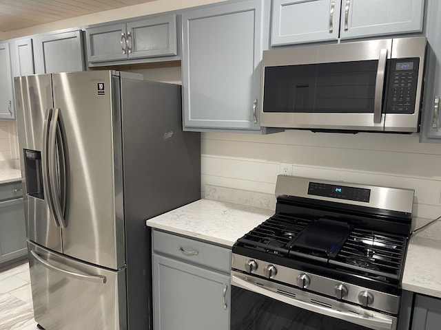 kitchen with gray cabinets and appliances with stainless steel finishes