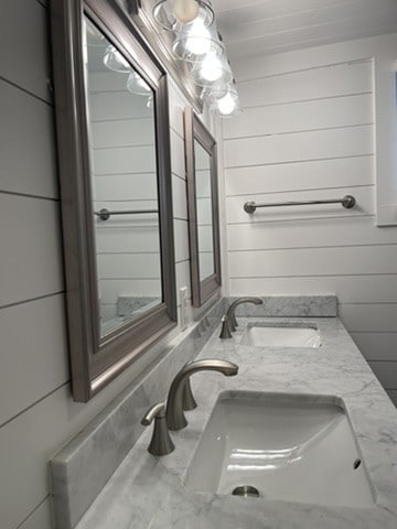 bathroom with vanity and wood walls