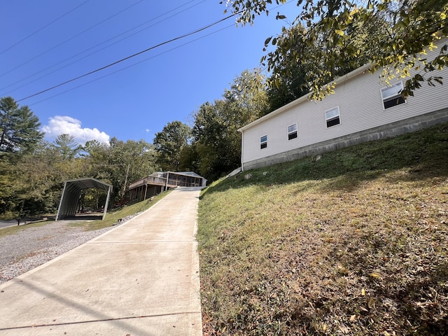 view of side of home with a yard and a carport