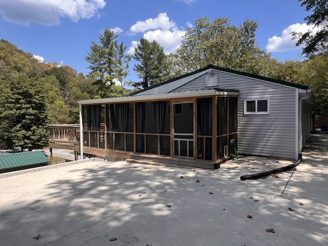 rear view of property featuring a sunroom