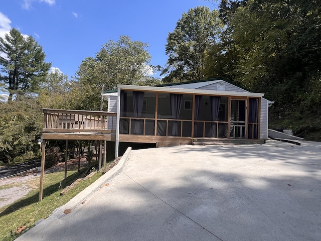 back of property featuring a sunroom and a deck