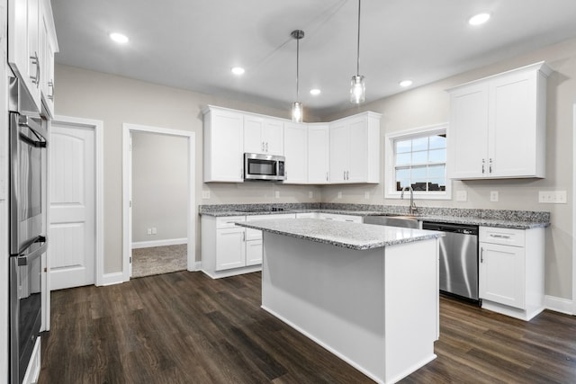 kitchen with white cabinets, pendant lighting, stainless steel appliances, and a kitchen island