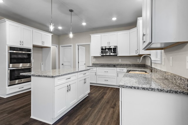 kitchen featuring a center island, dark wood-type flooring, sink, white cabinetry, and stainless steel appliances