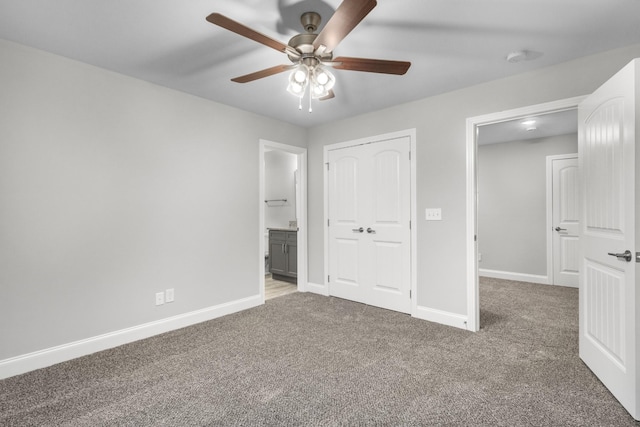 unfurnished bedroom featuring carpet flooring, ensuite bath, and ceiling fan