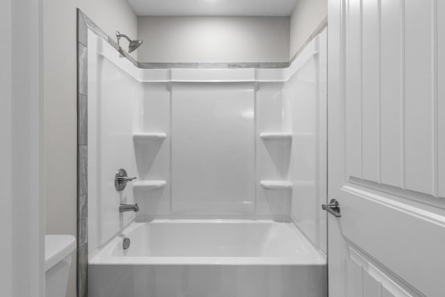 bathroom featuring shower / washtub combination and toilet