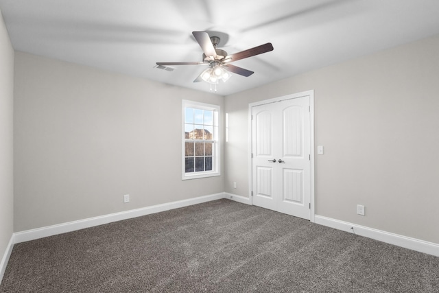 unfurnished bedroom featuring ceiling fan, a closet, and dark carpet