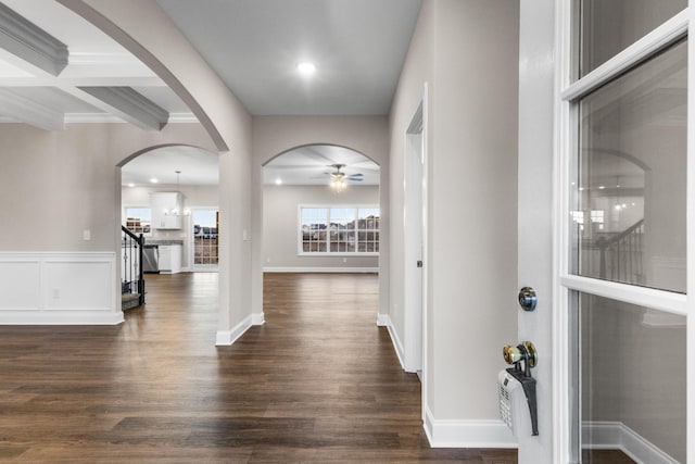 foyer featuring coffered ceiling, ceiling fan with notable chandelier, crown molding, dark hardwood / wood-style floors, and beam ceiling