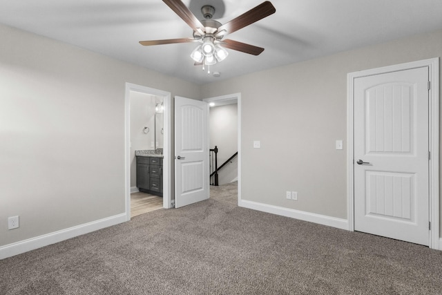 unfurnished bedroom with ensuite bath, ceiling fan, and light colored carpet