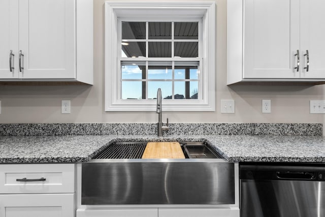 kitchen with white cabinetry, sink, stainless steel dishwasher, and light stone counters