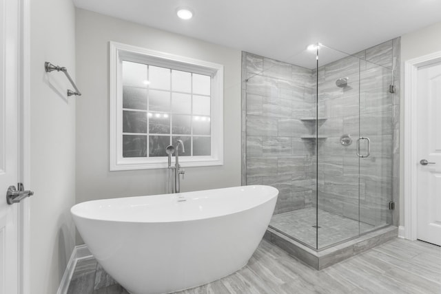 bathroom featuring plus walk in shower and wood-type flooring