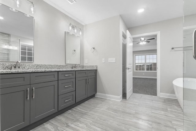 bathroom with ceiling fan, vanity, and a bath