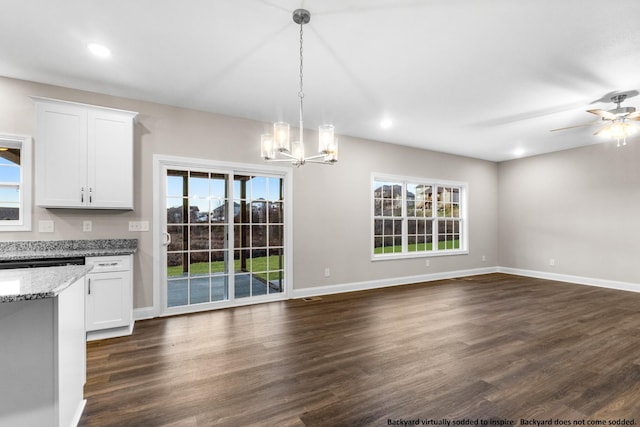 kitchen featuring light stone countertops, pendant lighting, dark hardwood / wood-style flooring, and white cabinetry