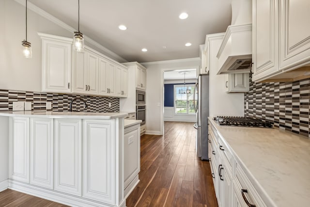 kitchen with appliances with stainless steel finishes, crown molding, hanging light fixtures, and backsplash