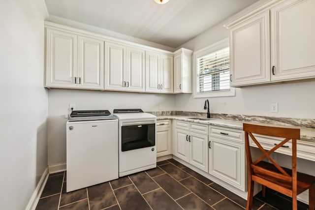 laundry room with cabinets, dark tile patterned floors, sink, and separate washer and dryer