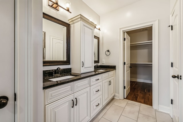 bathroom with tile patterned floors and double vanity