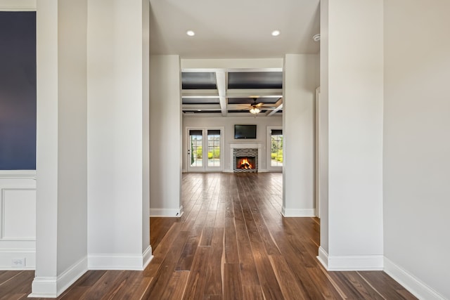 corridor featuring coffered ceiling, beamed ceiling, and dark hardwood / wood-style floors