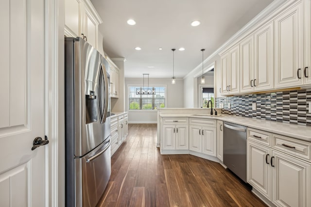 kitchen featuring dark hardwood / wood-style flooring, hanging light fixtures, appliances with stainless steel finishes, backsplash, and kitchen peninsula