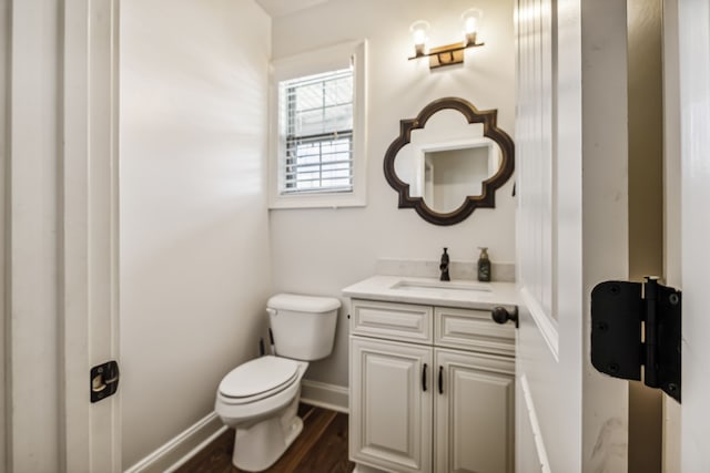 bathroom featuring toilet, vanity, and hardwood / wood-style flooring