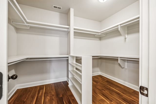 walk in closet with dark hardwood / wood-style flooring