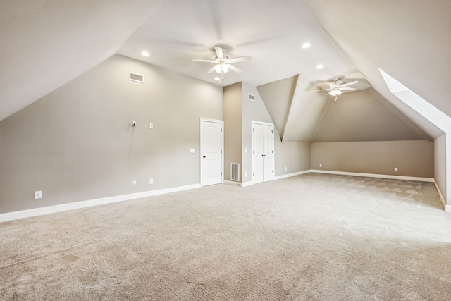 bonus room featuring ceiling fan, lofted ceiling with skylight, and light colored carpet