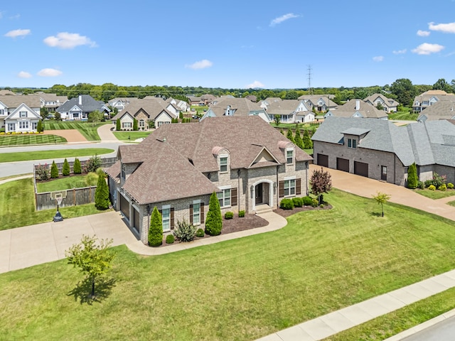 french provincial home with a front yard and a garage