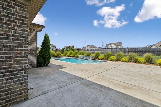 view of swimming pool featuring pool water feature and a patio