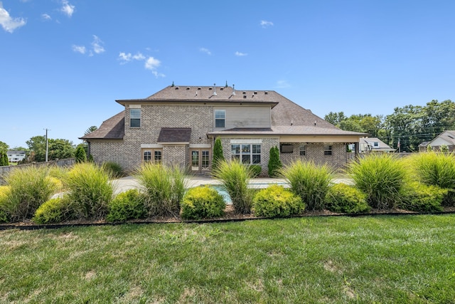 back of house with a lawn and a patio