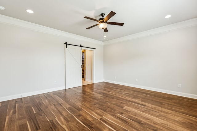 unfurnished room with ceiling fan, wood-type flooring, a barn door, and crown molding