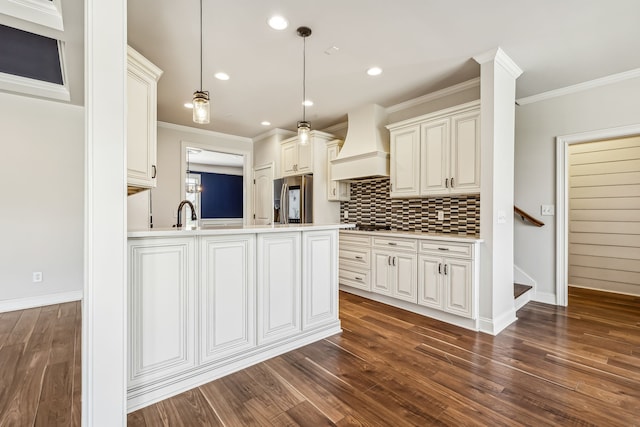 kitchen with dark hardwood / wood-style floors, stainless steel refrigerator with ice dispenser, custom range hood, pendant lighting, and tasteful backsplash