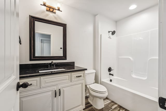 full bathroom featuring hardwood / wood-style flooring, vanity, bathing tub / shower combination, and toilet