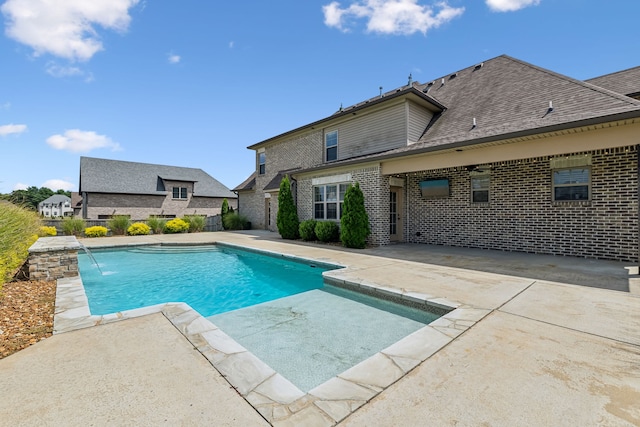 view of pool with pool water feature and a patio