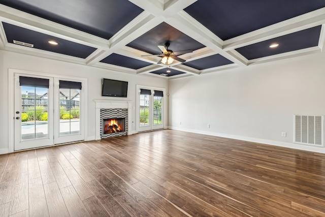 unfurnished living room featuring a fireplace, coffered ceiling, beam ceiling, ceiling fan, and hardwood / wood-style floors