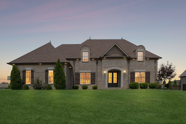 french country style house featuring a lawn