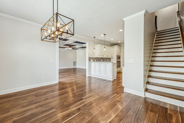 unfurnished living room featuring coffered ceiling, crown molding, ceiling fan with notable chandelier, wood-type flooring, and beamed ceiling