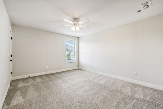 empty room with ceiling fan and light colored carpet